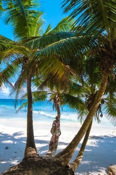 Anse Patates, La Digue Seychelles, a young couple of men and women on a tropical beach during a luxury vacation in Seychelles. Tropical beach Anse Patates, La Digue Seychelles