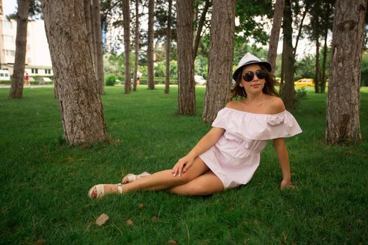 Beautiful girl in the park. Green grass and sunny weather.