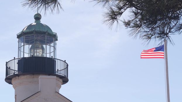 Vintage lighthouse tower, retro light house, old historic classic beacon with fresnel lens, american flag. Nautical navigation, 1855. Point Loma, San Diego, California USA. Seamless looped cinemagraph