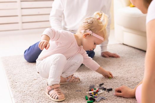 Cochlear implant on the child girl head and playing with mother and father. Hearing aid and deafness and innovative health technology