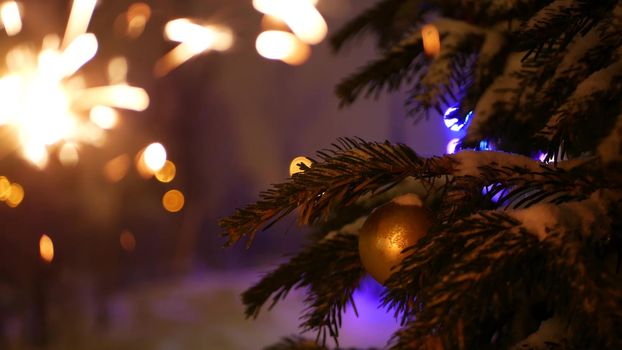 Christmas tree in snow, sparkler firework burning, New Year or Xmas bengal light. Winter holiday magic, sparkles, flakes, golden stars. Spruce, pine or fir in snowflakes. Seamless looped cinemagraph.
