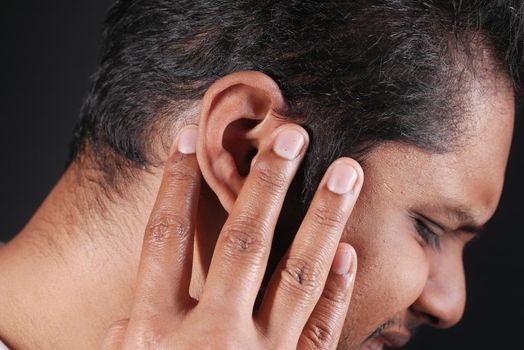 young man having ear pain touching his painful ear