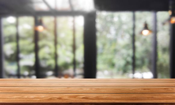 Wood table in blurry background of modern restaurant room or coffee shop with empty copy space on the table for product display mockup. Interior restaurant counter design concept.