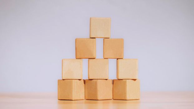 Stacking blank wooden cubes or arrange the wooden blocks on table for input wording and infographic icon. Business concept growth success process, ladder of success, Driving business at peak concept.