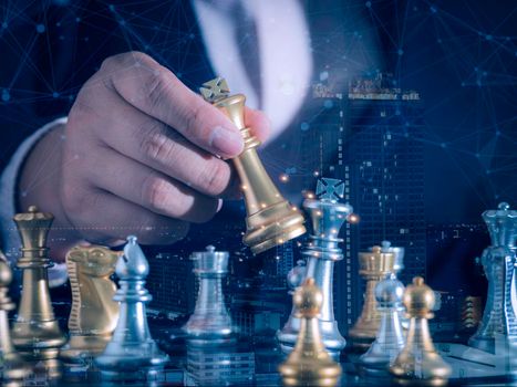 Hand of businessman moving gold king chess figure in competition success with double exposure digital graphic network line connecting diagram business.Strategy, leadership and management ideas concept