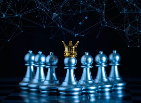 A silver pawn standing crowned in battle chess game on board with gold chess background. successfully in the competition with technology network background. Management or leadership strategy concept.