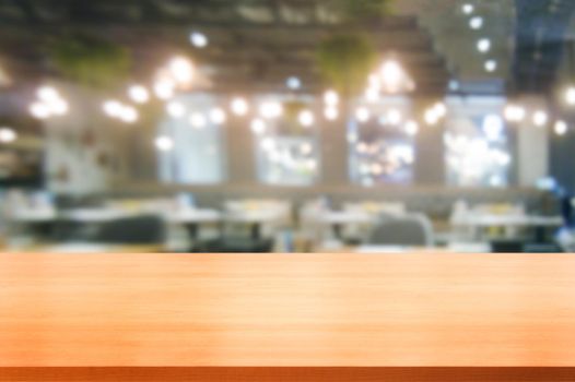Wood table in blurry background of modern restaurant room or coffee shop with empty copy space on the table for product display mockup. Interior restaurant counter design concept.