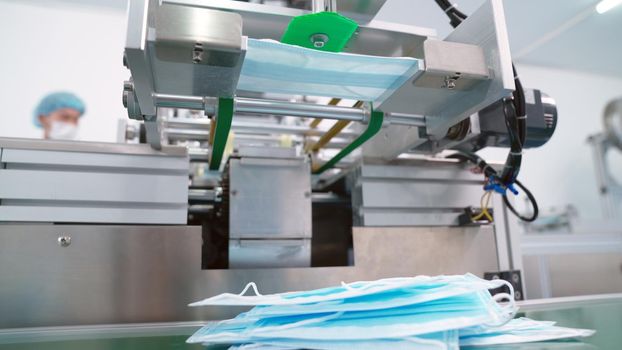 Face mask production line in modern factory . Concept of covid-19 coronavirus 2019 provention .