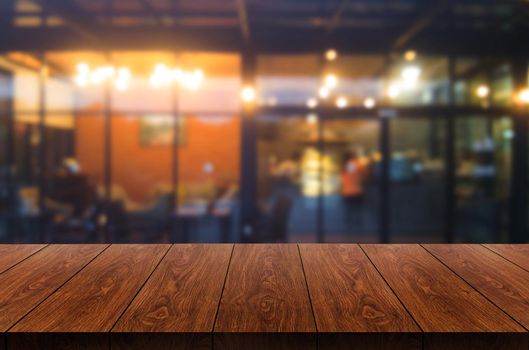 Wood table in blurry background of modern restaurant room or coffee shop with empty copy space on the table for product display mockup. Interior restaurant counter design concept.