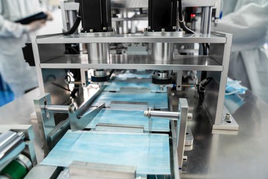 Face mask production line in modern factory . Concept of covid-19 coronavirus 2019 provention .