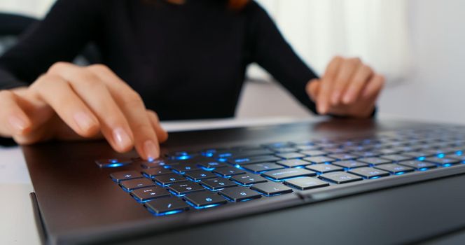 Woman Typing On A Laptop With An RGB Keyboard.
