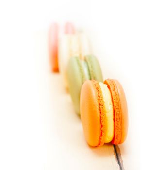 colorful french macaroons over a white rustic wood table 