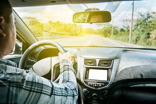 Man's hands on the wheel of the car, a person driving with hands on the wheel, inside view of a man driving a car, Concept of hands on the wheel of a car