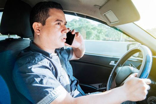 Concept of man calling on the phone while driving, A man driver calling on the phone in his car, Close up of a young man sitting inside car using mobile phone