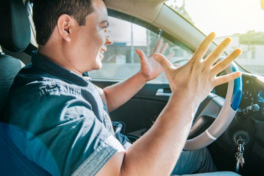 Impatient driver yelling, portrait of angry driver yelling in his car, stressed driver man yelling at other driver, concept of impatient driver yelling