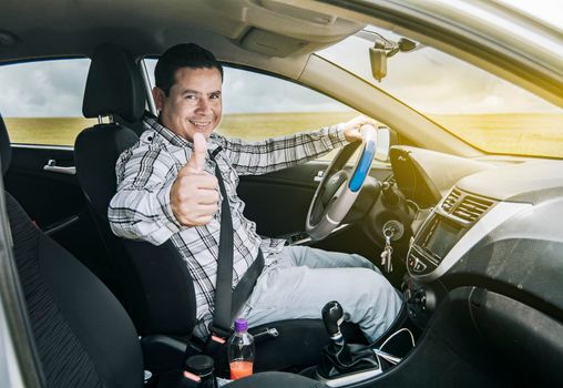 Man in his car giving a thumbs up, happy man in his car giving a thumbs up, portrait of a man showing thumbs up while driving