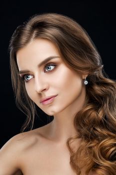 Studio fashion portrait of attractive sensual young woman with long wavy fair hair and blue eyes looking at camera. Natural beauty concept. Caucasian.