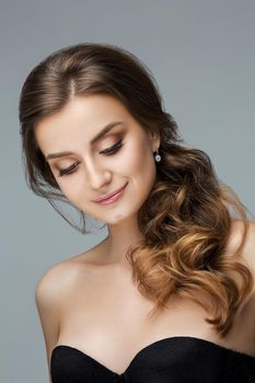 Studio fashion portrait of attractive sensual young woman with long wavy fair hair and blue eyes looking at camera. Natural beauty concept. Caucasian.