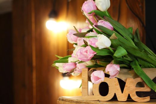 Bouquet of tulips on a wooden rustic table. Spring holidays concept background.