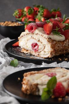 Meringue roll cake with cream, raspberries. Roulade, summer dessert served in ceramic plate.