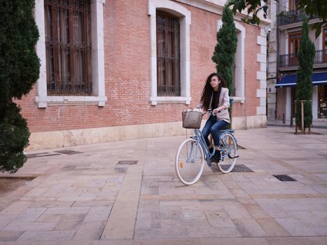 young woman on her way to work in a environmentally friendly vehicle, horizontal urban background