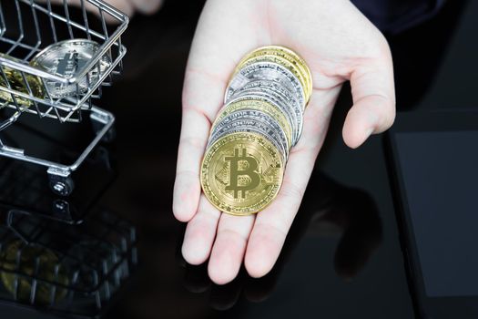 Closeup image of a business women holding and giving golden color bitcoins