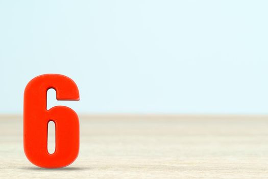 Shot of a number six made of red plastic on table with copy space