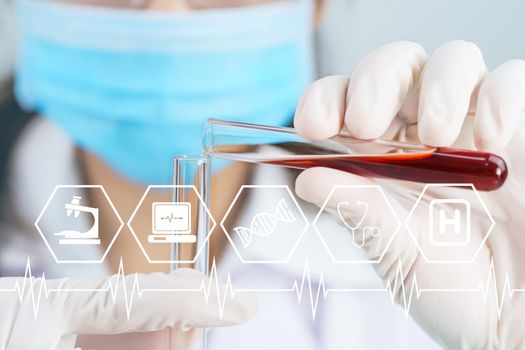 Technician scientist analyzing holding blood sample in test tube in laboratory for testing it on  COVID-19, coronavirus virus analysis