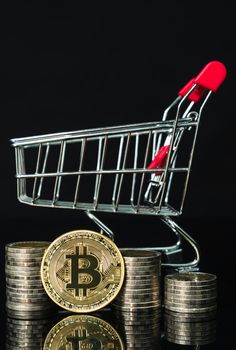 Close up Bitcoin coin in shopping cart on black background