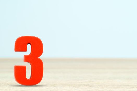 Shot of a number three made of red plastic on table with copy space