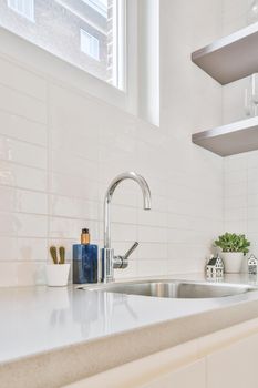 Kitchen faucet close-up on a marble countertop in a modern home