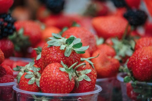 Selective focus. fresh strawberries, raspberries and blackberries in a glass. Summer Beach Food.