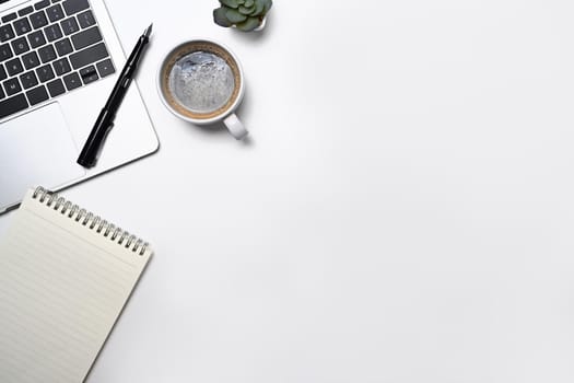 Minimal workplace with laptop computer, coffee cup, notepad and potted plant. Flat lay, Top view with copy space.