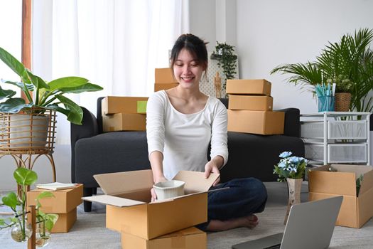 Young start up small business entrepreneur preparing parcel boxes for delivery.