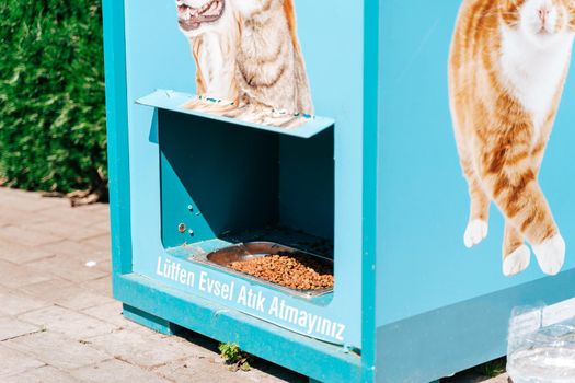 Homeless animals dog cat food vending machine close-up. Outdoors food dispenser. Street pet feeder in turkey. Text - please don't throw out the trash