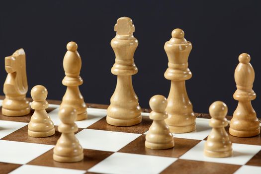 Chess board with chess pieces on gray background Selective focus on white king.