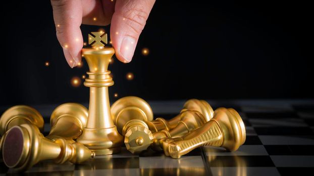 Hand of businessman holding the golden king chess to fighting silver king chess to play successfully in the competition with technology network background. Management or leadership strategy concept.
