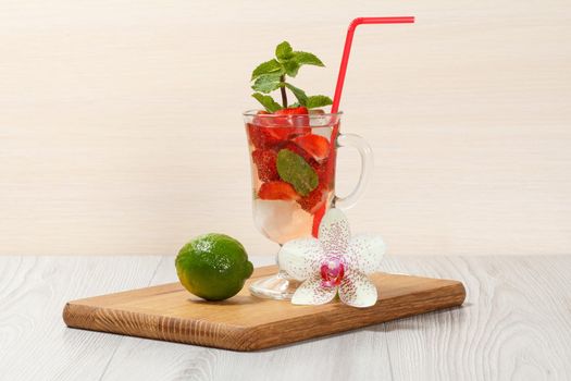 Carbonated lemonade with strawberry slices and mint on an wooden cutting board, Cold beverage for hot summer day