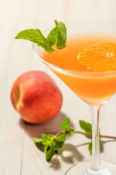 Orange jelly in the glass topped mint leaves with nectarine on the background Close up selective focus