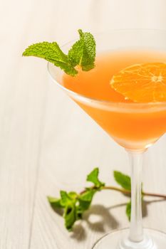 Orange jelly in the glass topped mint leaves on the wooden background Close up selective focus