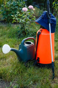 Fertilizer pesticide garden sprayer and watering can on lawn with green grass