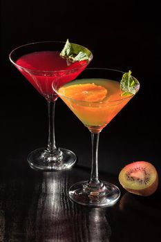 Cherry and orange jelly with lime pieces in the glasses topped mint leaves on the black background