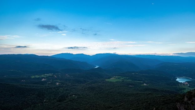 Twilight over the mountains and forest. Blue colors and a lot of peaceful silence.