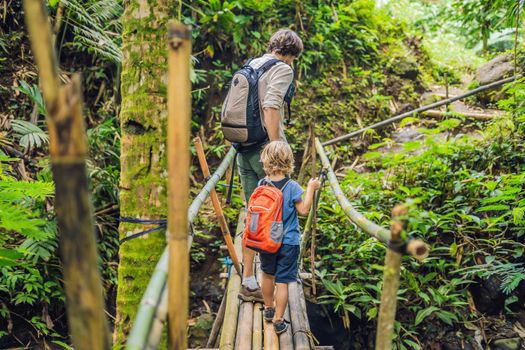 Father and son travelers on the suspension bridge in Bali. Traveling with children concept..