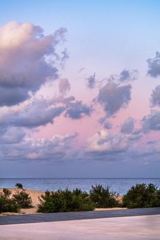 Pink sky with clouds over the sea during the sunset at the beach. Badalona, Barcelona, Catalonia, Spain. Vertical shot.
