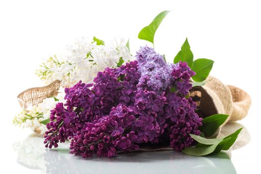 Bouquet of beautiful spring lilacs of different colors on a wooden table