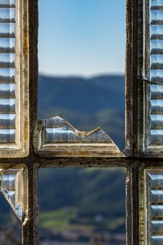 View of the mountains through the broken window in abandoned building. Spain.