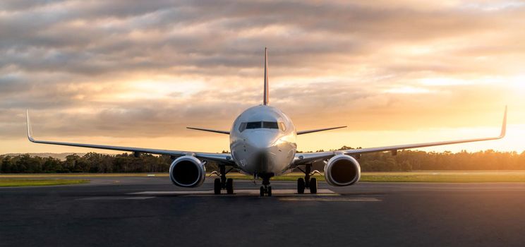 Sunset view of airplane on airport runway under dramatic sky in Hobart,Tasmania, Australia. Aviation technology and world travel concept.