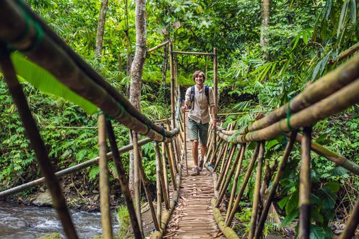 Male traveler on the suspension bridge in Bali.