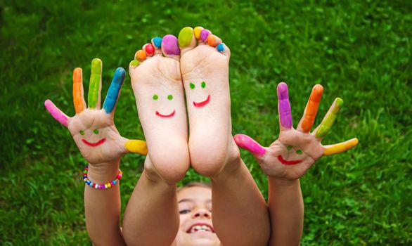 Children's feet with a pattern of paints smile on the green grass. Selective focus.child